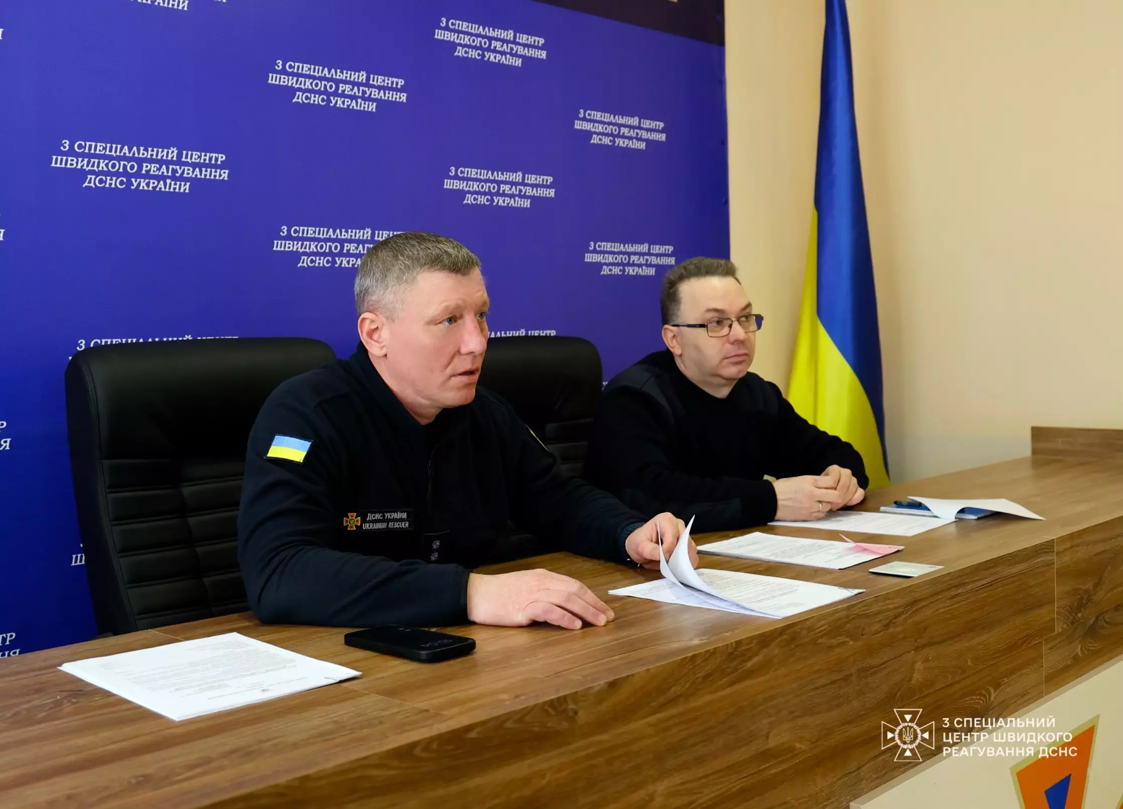 На фото зображено заступника начальника центру з оперативного реагування Вадима Янішевського за столом та Олександра Ковалевського